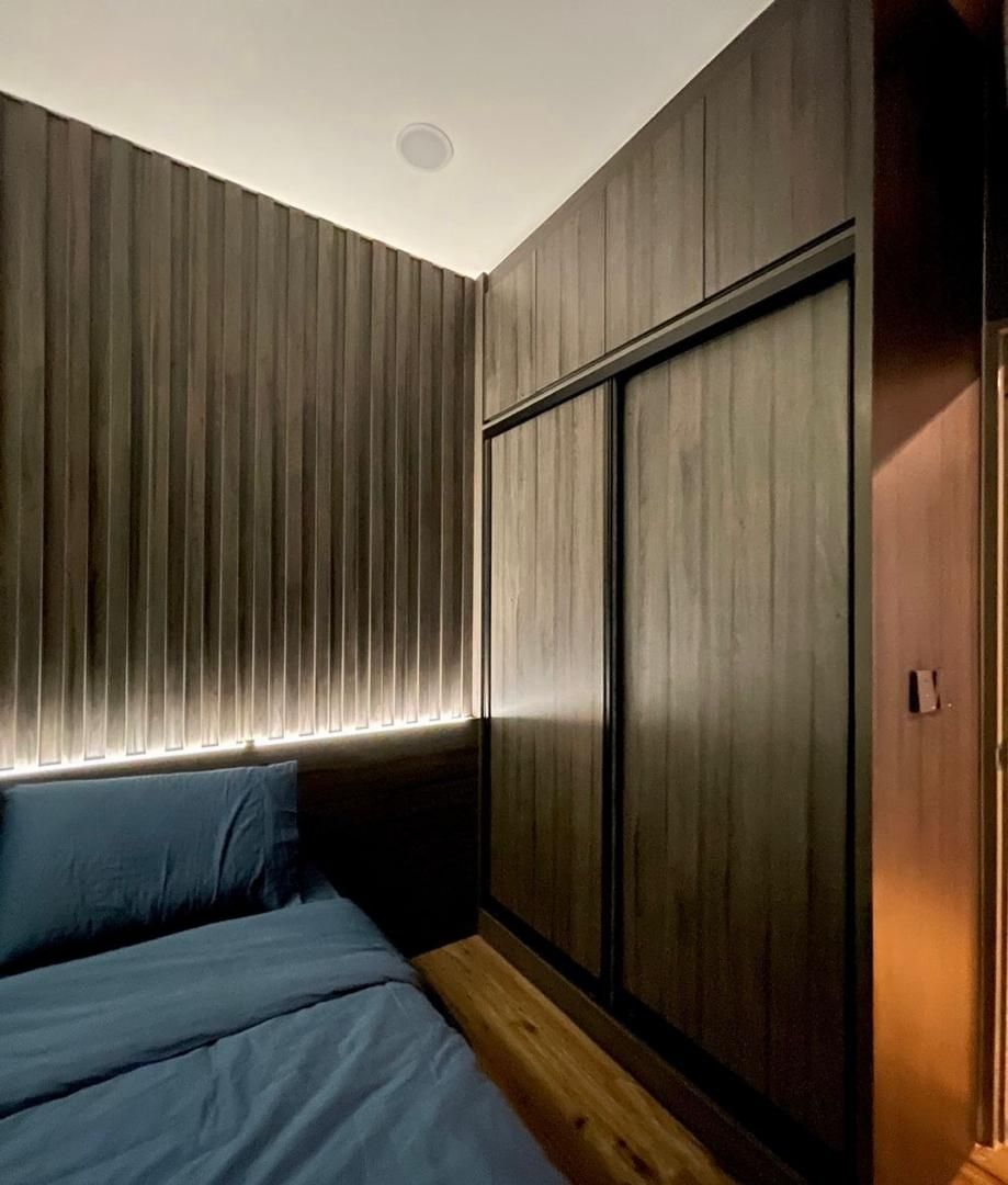 Bedroom with fluted wall and wardrobe
